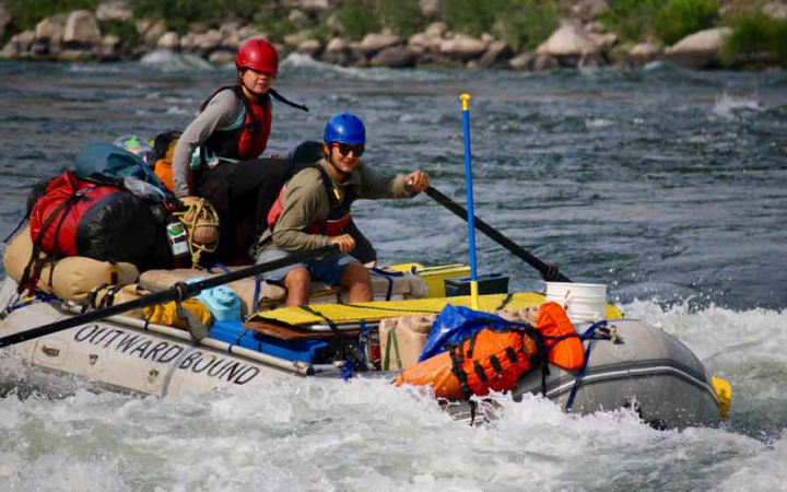 two people navigate whitewater in a raft 